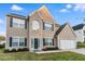 Charming two-story home features a brick facade, blue shutters, landscaped yard, and an attached two-car garage at 2902 Framer Ln, Durham, NC 27704