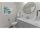 Bathroom featuring updated vanity and round mirror at 306 Coleman St, Oxford, NC 27565