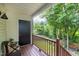 Inviting covered back porch with railing overlooking mature trees, perfect for relaxing outdoors at 309 Cross Hill Ln, Holly Springs, NC 27540