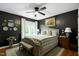 Bedroom with black walls, hardwood flooring, and a ceiling fan at 309 Cross Hill Ln, Holly Springs, NC 27540