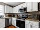 Modern kitchen featuring stainless steel appliances, granite countertops, and plenty of cabinet space at 309 Cross Hill Ln, Holly Springs, NC 27540