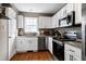 Well-lit kitchen with granite countertops, stainless steel appliances, and classic white cabinets at 309 Cross Hill Ln, Holly Springs, NC 27540