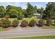 Aerial shot of the home with a circular driveway, mature trees, and a flag at 3123 Brassfield Rd, Creedmoor, NC 27522