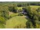 Expansive aerial view of the property showcasing lush green fields and mature trees at 3123 Brassfield Rd, Creedmoor, NC 27522
