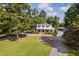 Aerial view of the home with mature trees, long driveway, and manicured landscaping at 3123 Brassfield Rd, Creedmoor, NC 27522