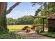 Scenic backyard with a rustic bar, charming seating area, and expansive green lawn at 3123 Brassfield Rd, Creedmoor, NC 27522