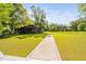 Wide angle view of barn with rustic architecture on a green lawn, accented by a brick pathway to a deck at 3123 Brassfield Rd, Creedmoor, NC 27522