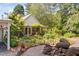 Quaint cottage surrounded by lush gardens, a stone pathway, mature trees and natural beauty at 3123 Brassfield Rd, Creedmoor, NC 27522