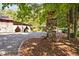 Rustic directional sign amidst lush greenery pointing towards various attractions on the property at 3123 Brassfield Rd, Creedmoor, NC 27522