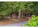 Rustic exterior featuring several small buildings surrounded by lush trees at 3123 Brassfield Rd, Creedmoor, NC 27522