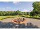 Brick fire pit area with gravel surrounding, and picturesque meadow views at 3123 Brassfield Rd, Creedmoor, NC 27522