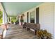 Welcoming front porch with wooden floors, bench seating, and inviting plants at 3123 Brassfield Rd, Creedmoor, NC 27522