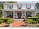 Inviting front porch with classic columns, red door, and lush landscaping at 3123 Brassfield Rd, Creedmoor, NC 27522