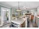 Large open kitchen with a central island, rustic wood accents, and a view into the living area at 3123 Brassfield Rd, Creedmoor, NC 27522