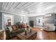 Comfortable living room with natural light, a plush sofa, and hardwood flooring at 3123 Brassfield Rd, Creedmoor, NC 27522