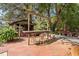 Charming outdoor bar area with brick patio, rustic wood bar, and comfortable seating under mature trees at 3123 Brassfield Rd, Creedmoor, NC 27522