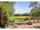 Outdoor patio showcasing brick flooring, fireplace, wicker furniture, and a picturesque view of the green meadow at 3123 Brassfield Rd, Creedmoor, NC 27522