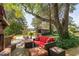 Inviting outdoor patio with comfortable seating, brickwork, lush greenery, and a charming bar in the background at 3123 Brassfield Rd, Creedmoor, NC 27522