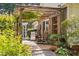 Relaxing outdoor patio with brick flooring, overhead trellis, comfortable seating, and charming garden views at 3123 Brassfield Rd, Creedmoor, NC 27522