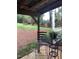 An inviting outdoor seating area featuring a bistro set with a view of a beautifully landscaped backyard at 3123 Brassfield Rd, Creedmoor, NC 27522