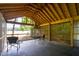 Relaxing covered patio with seating and hammock chair overlooking a beautiful field view at 3123 Brassfield Rd, Creedmoor, NC 27522
