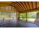 Spacious porch with screened windows offering a serene view of the surrounding greenery at 3123 Brassfield Rd, Creedmoor, NC 27522