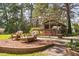 Outdoor entertainment area, featuring a 'Sugar Shack' bar, wicker furniture, and beautifully landscaped surroundings at 3123 Brassfield Rd, Creedmoor, NC 27522