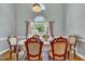 Elegant dining room with a large window, decorative curtains, and a formal dining table set for six at 316 Waterford Dr, Clayton, NC 27520