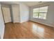 Bedroom with hardwood floors, a window, and an adjacent closet and door at 358 Red Elm Dr, Durham, NC 27713