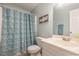 Bright bathroom features a vanity sink, toilet, and shower with a decorative floral shower curtain at 400 Southerby Dr, Garner, NC 27529