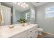 Bathroom with a double sink vanity with white cabinets and a large mirror and window at 400 Southerby Dr, Garner, NC 27529