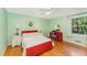 This bedroom features light green walls, hardwood floors, and a red vanity with a light blue chair at 4017 Huckleberry Dr, Raleigh, NC 27612