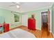 This bedroom features light green walls, hardwood floors, a window, and a red chest of drawers at 4017 Huckleberry Dr, Raleigh, NC 27612