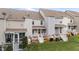 A view of multiple townhomes, each featuring a rear porch and well-maintained lawn at 407 Whitehall Ct, Clayton, NC 27520