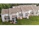 A view of multiple townhomes, each featuring a rear porch and well-maintained lawn at 407 Whitehall Ct, Clayton, NC 27520
