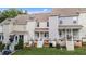 A view of multiple townhomes, each featuring a rear porch and well-maintained lawn at 407 Whitehall Ct, Clayton, NC 27520