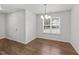 Dining area with wood-look floors, a modern chandelier, and natural light from the window at 407 Whitehall Ct, Clayton, NC 27520
