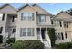 Charming townhome featuring gray siding, blue shutters, a quaint front porch, and a tidy, landscaped yard at 407 Whitehall Ct, Clayton, NC 27520