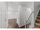 Bright hallway with white walls, wood-look floors, and staircase leading to upper level at 407 Whitehall Ct, Clayton, NC 27520