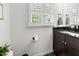 Bathroom vanity with dark wood cabinets, black countertops, and framed window at 4112 Huckleberry Dr, Raleigh, NC 27612