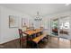 Elegant dining room with modern chandelier, wood table, and access to outdoor patio at 4112 Huckleberry Dr, Raleigh, NC 27612