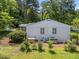 The exterior of the home features a white brick facade with green landscaping, shrubs, and trees at 4112 Huckleberry Dr, Raleigh, NC 27612