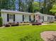 Inviting home with a rocking chair front porch, American flag, black shutters, and manicured landscaping at 4112 Huckleberry Dr, Raleigh, NC 27612