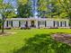 Beautiful white brick home with lush green lawn and flowering bushes creates a welcoming scene at 4112 Huckleberry Dr, Raleigh, NC 27612