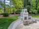 Outdoor fireplace with a seating area nestled in a lush backyard at 4112 Huckleberry Dr, Raleigh, NC 27612