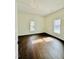 Sunny bedroom with hardwood floors, neutral walls, and bright natural light from dual windows at 425 Price Ave, Durham, NC 27707