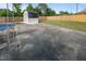 Large concrete patio with a wooden fence, green grass, and a storage shed in the backyard at 464 Camp Rd, Burlington, NC 27217