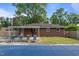 Backyard with a covered pool, brick house, 4 lawn chairs, and a grassy lawn at 464 Camp Rd, Burlington, NC 27217