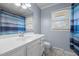 Bathroom featuring a white vanity, mirror, light blue walls, a window, and blue shower curtain at 464 Camp Rd, Burlington, NC 27217