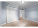 This is a bedroom with carpeted floors, light blue walls, and a double door closet at 464 Camp Rd, Burlington, NC 27217